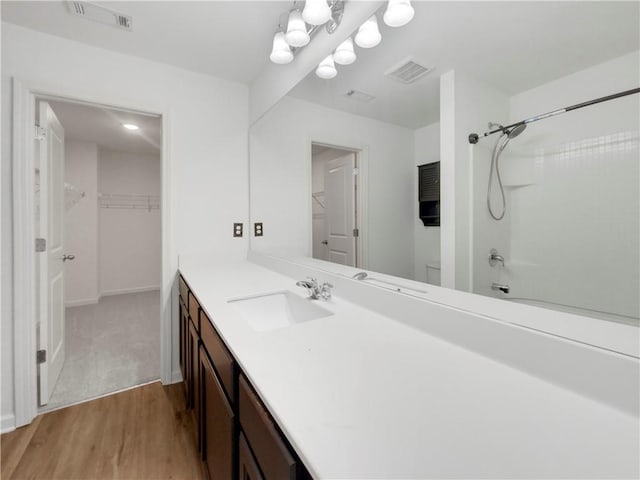 bathroom featuring shower / bathtub combination, hardwood / wood-style floors, and vanity