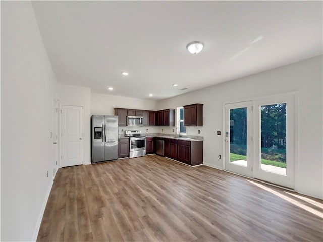 kitchen featuring stainless steel appliances, sink, and light hardwood / wood-style floors