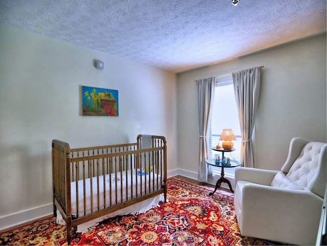 2210 Cumberland Ct SE, Smyrna, GA 30080 - bedroom with baseboards, a textured ceiling, and a nursery area