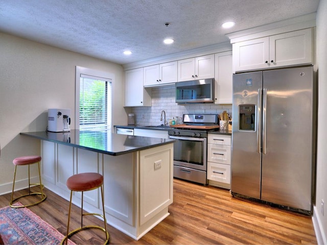 2210 Cumberland Ct SE, Smyrna, GA 30080 - kitchen with stainless steel appliances, a sink, dark countertops, recessed lighting, and a textured ceiling