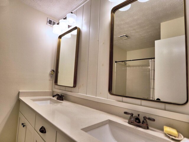 2210 Cumberland Ct SE, Smyrna, GA 30080 - bathroom with a textured ceiling and double vanity