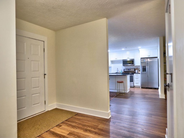 2210 Cumberland Ct SE, Smyrna, GA 30080 - corridor with dark wood-style flooring, baseboards, a sink, and a textured ceiling