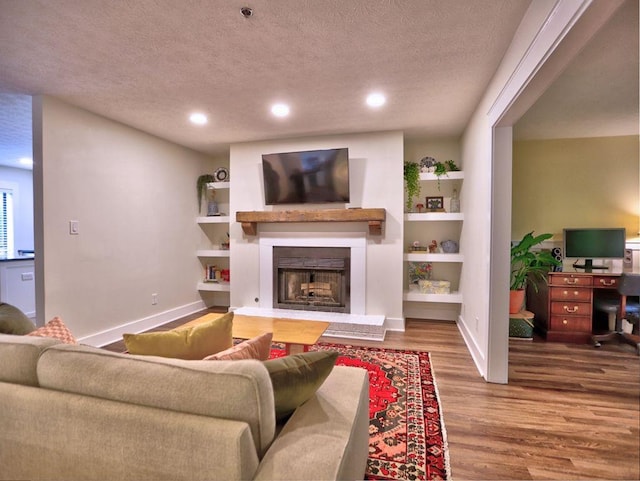 2210 Cumberland Ct SE, Smyrna, GA 30080 - living room with wood finished floors, a fireplace, a textured ceiling, baseboards, and recessed lighting