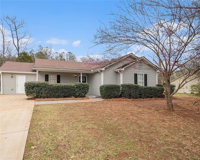 ranch-style home with concrete driveway and a front yard