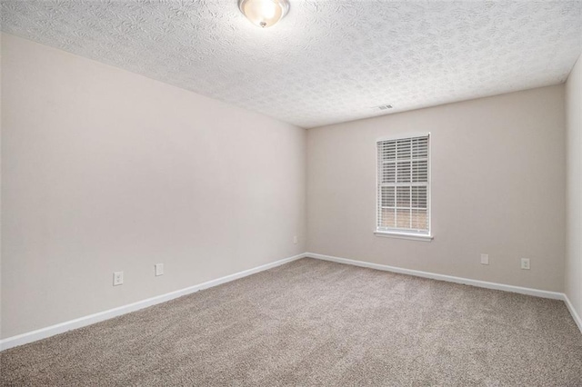 unfurnished room with carpet floors, a textured ceiling, and baseboards