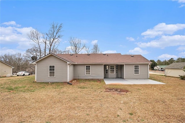 back of property with a patio area and a yard