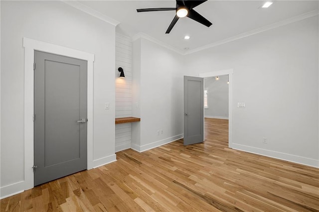 interior space featuring crown molding, baseboards, recessed lighting, a ceiling fan, and light wood finished floors