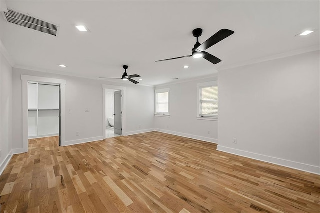 interior space with crown molding, a ceiling fan, light wood-type flooring, and visible vents