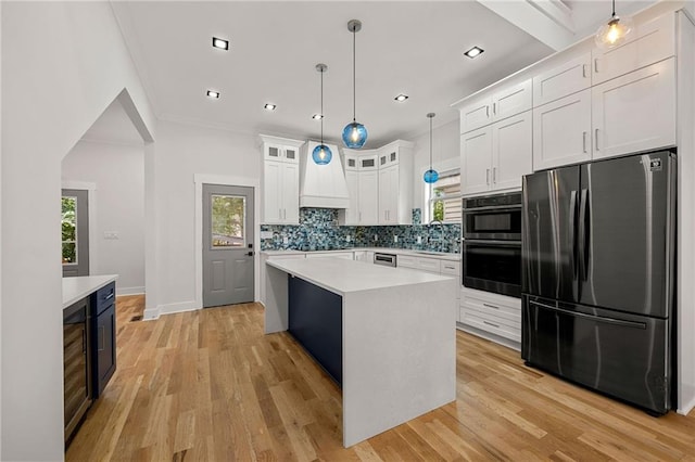 kitchen with a center island, white cabinetry, plenty of natural light, appliances with stainless steel finishes, and light hardwood / wood-style floors