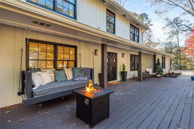 deck with an outdoor living space with a fire pit