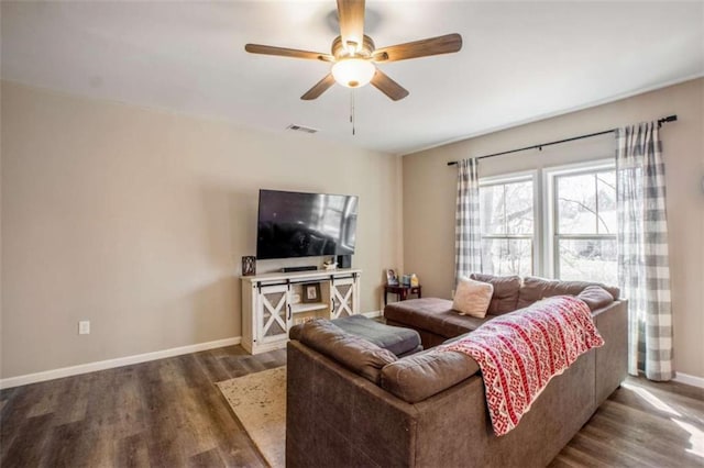 living area featuring a ceiling fan, wood finished floors, visible vents, and baseboards