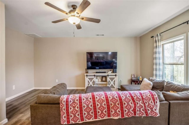 living room featuring ceiling fan, wood finished floors, visible vents, and baseboards