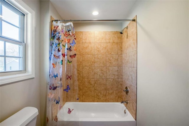 bathroom with shower / tub combo with curtain and toilet