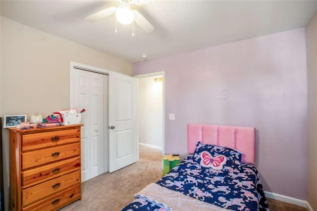 bedroom featuring light carpet, a closet, a ceiling fan, and baseboards