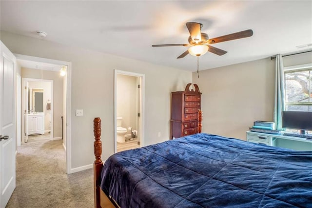 carpeted bedroom with a ceiling fan, attic access, baseboards, and connected bathroom