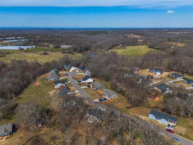 bird's eye view with a wooded view