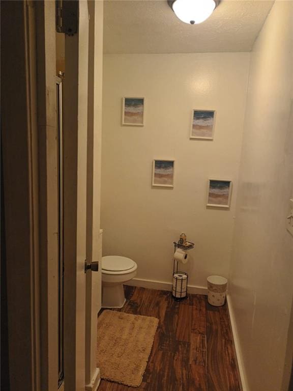 bathroom with wood-type flooring and toilet