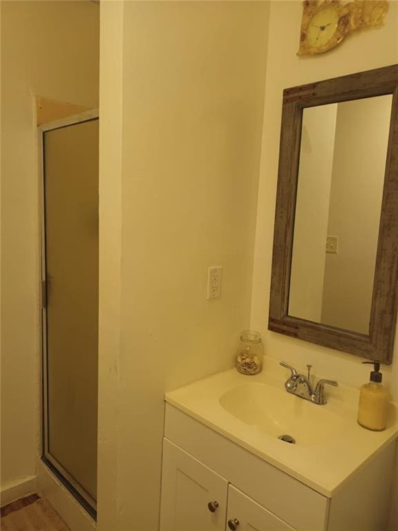 bathroom with vanity, a shower with shower door, and wood-type flooring