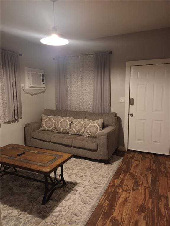 living room with an AC wall unit and dark hardwood / wood-style flooring