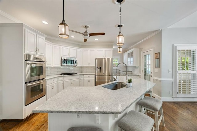 10000 Groomsbridge Rd, Johns Creek, GA 30022 - kitchen featuring appliances with stainless steel finishes, a sink, white cabinets, tasteful backsplash, and crown molding