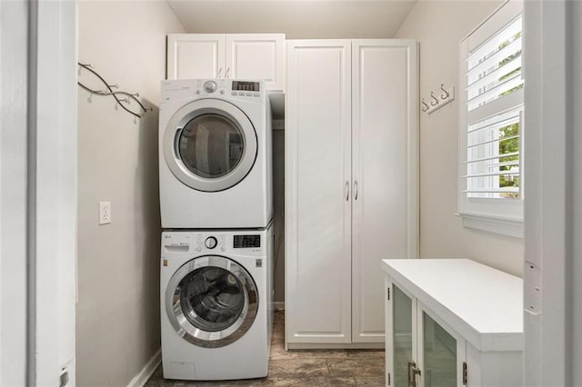 10000 Groomsbridge Rd, Johns Creek, GA 30022 - washroom featuring estacked washer and dryer, cabinet space, wood finished floors, and baseboards