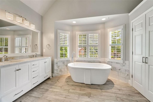 10000 Groomsbridge Rd, Johns Creek, GA 30022 - full bath featuring tile walls, wainscoting, lofted ceiling, double vanity, and a freestanding bath