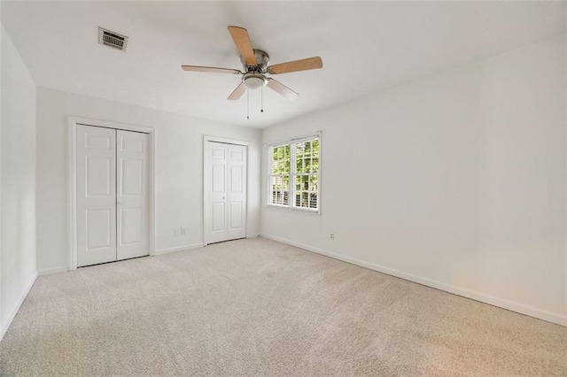 10000 Groomsbridge Rd, Johns Creek, GA 30022 - unfurnished bedroom featuring multiple closets, light carpet, baseboards, and a ceiling fan
