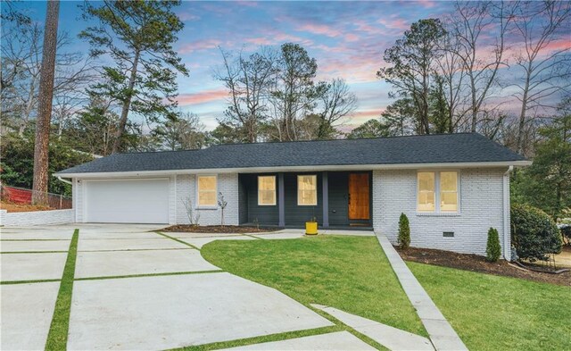 single story home featuring a lawn and a garage