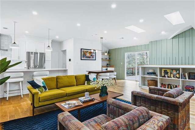 living room with vaulted ceiling and light hardwood / wood-style floors