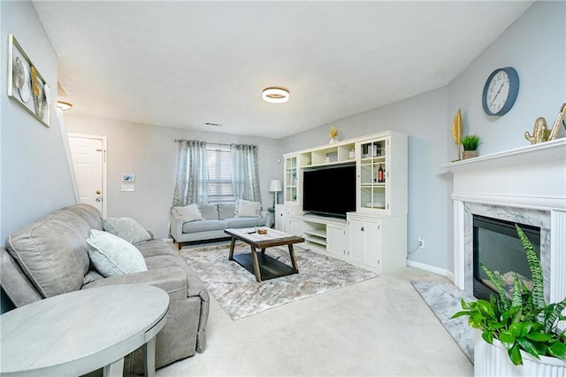 carpeted living room featuring a high end fireplace