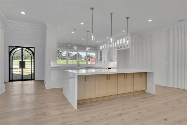 3903 Indian Shoals Rd SE, Bethlehem, GA 30620 - kitchen featuring light countertops, light wood-type flooring, a spacious island, white cabinets, and recessed lighting