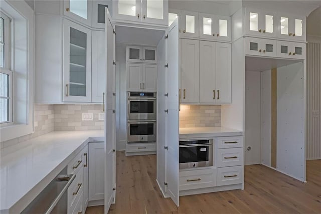 3903 Indian Shoals Rd SE, Bethlehem, GA 30620 - kitchen featuring stainless steel double oven, white cabinetry, light wood-type flooring, and light countertops
