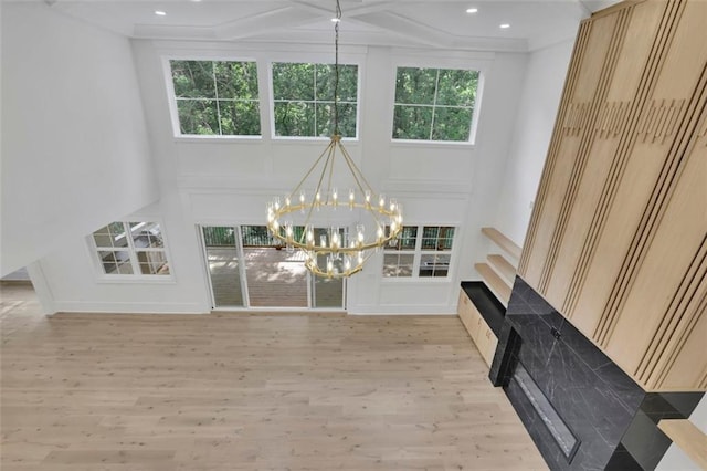 3903 Indian Shoals Rd SE, Bethlehem, GA 30620 - unfurnished living room featuring a chandelier, light wood-style flooring, recessed lighting, a fireplace, and a high ceiling