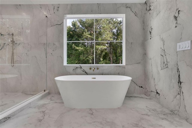 3903 Indian Shoals Rd SE, Bethlehem, GA 30620 - bathroom featuring marble tiled floors, a soaking tub, a marble finish shower, and stone wall