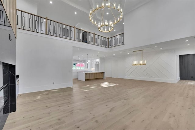 3903 Indian Shoals Rd SE, Bethlehem, GA 30620 - unfurnished living room with a high ceiling, light wood finished floors, a chandelier, and recessed lighting