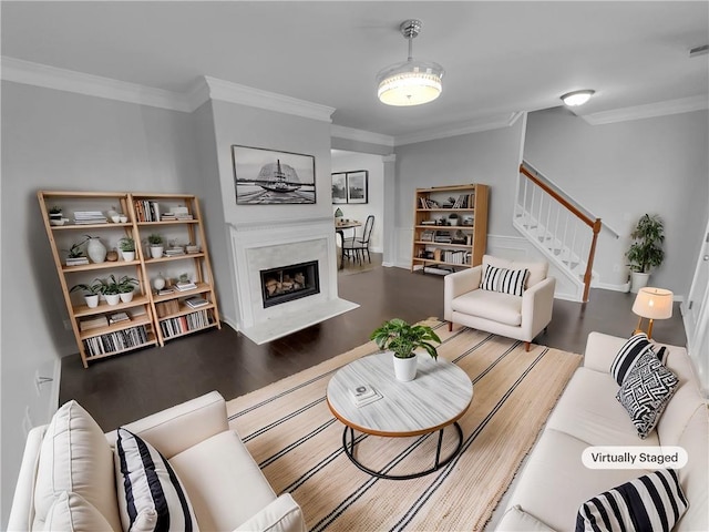 living room featuring ornamental molding, stairway, a fireplace, and wood finished floors