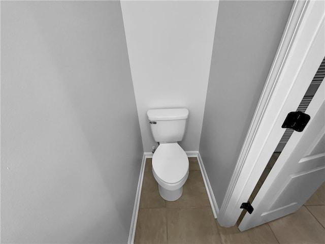 bathroom featuring tile patterned flooring, toilet, and baseboards