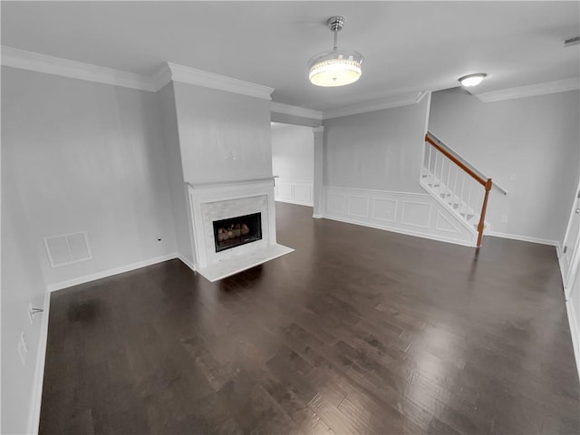 unfurnished living room with dark wood-style floors, visible vents, stairway, ornamental molding, and a high end fireplace