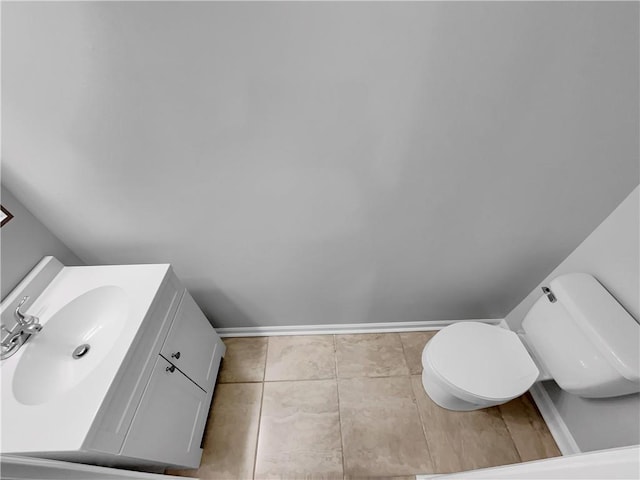 bathroom with baseboards, vanity, toilet, and tile patterned floors