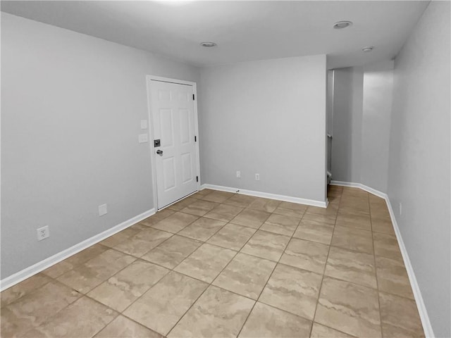 unfurnished room with light tile patterned floors and baseboards