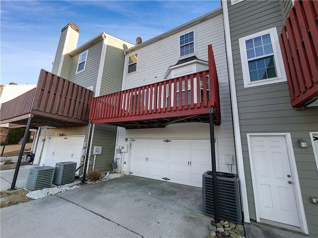 back of house with central AC unit and an attached garage