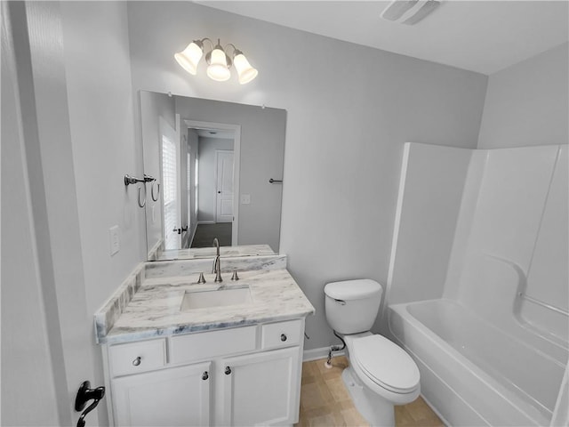 bathroom featuring toilet, vanity, visible vents, baseboards, and washtub / shower combination