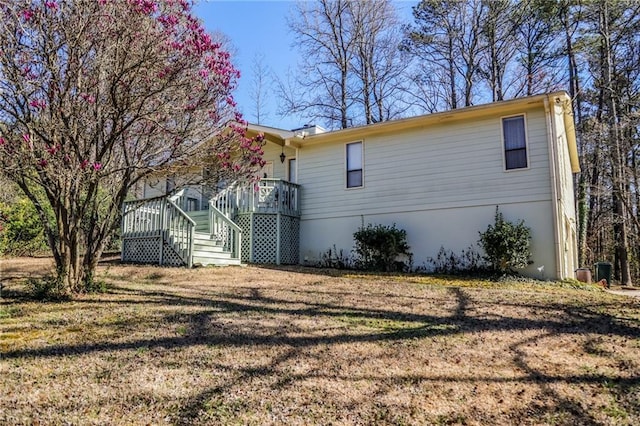 view of side of property with a lawn and stairs