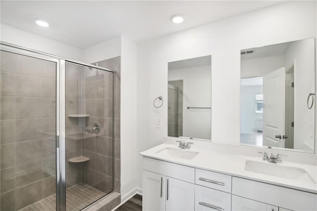 bathroom featuring hardwood / wood-style flooring, vanity, and a shower with door