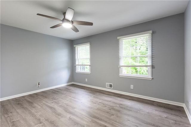 spare room with a ceiling fan, wood finished floors, and baseboards