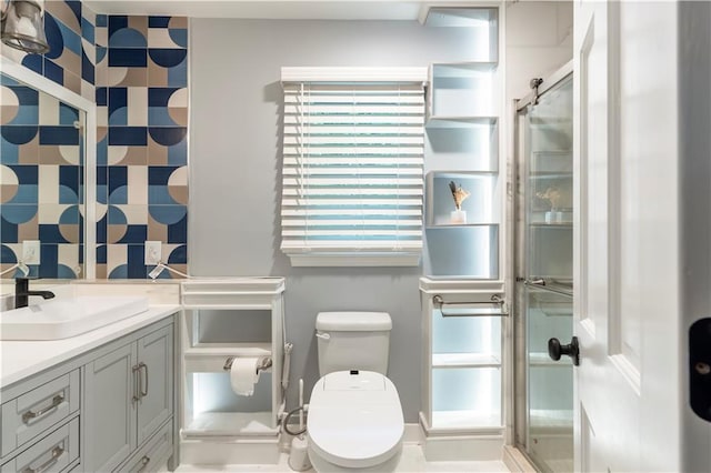 bathroom featuring toilet, vanity, and a stall shower