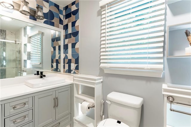 bathroom with a stall shower, plenty of natural light, toilet, and vanity