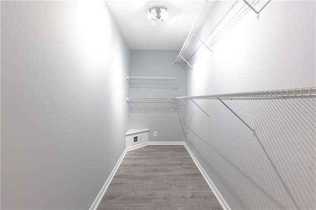 walk in closet with wood finished floors