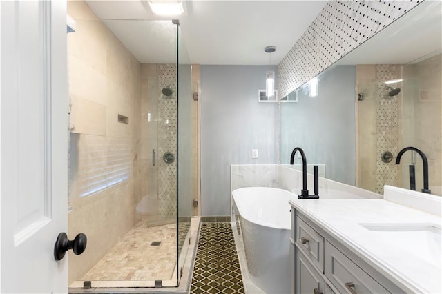 bathroom featuring a shower stall, a soaking tub, vanity, and baseboards