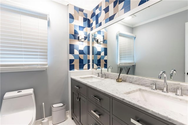 full bathroom featuring toilet, crown molding, double vanity, and baseboards